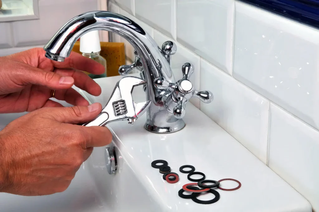 Plumber performing maintenance on a bathroom faucet in Newnan