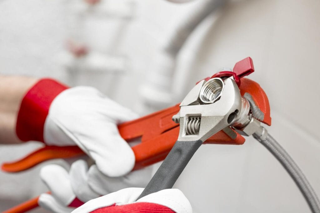 Plumber holding pipe wrenches for an emergency repair in Newnan