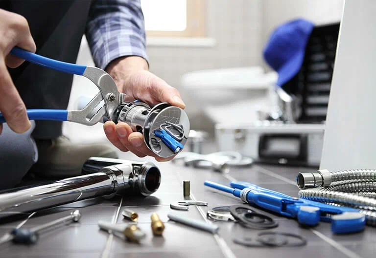 Technician repairing a plumbing fixture with professional tools in Newnan