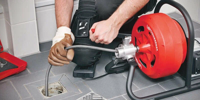 Plumber using a drain-cleaning machine in Newnan