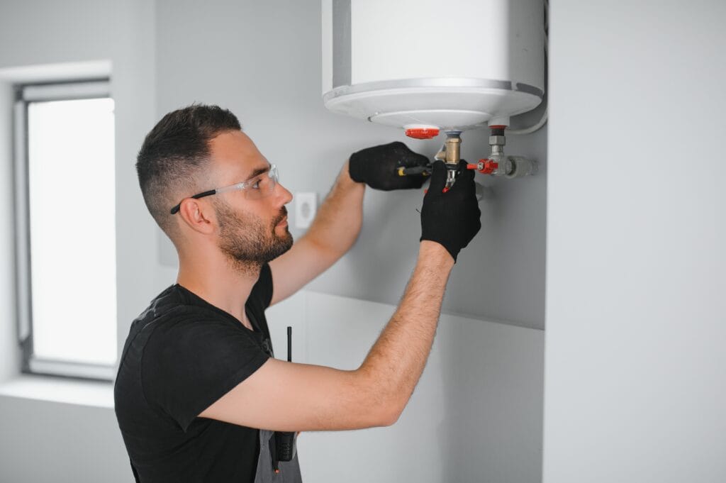 Technician performing water heater maintenance in Newnan