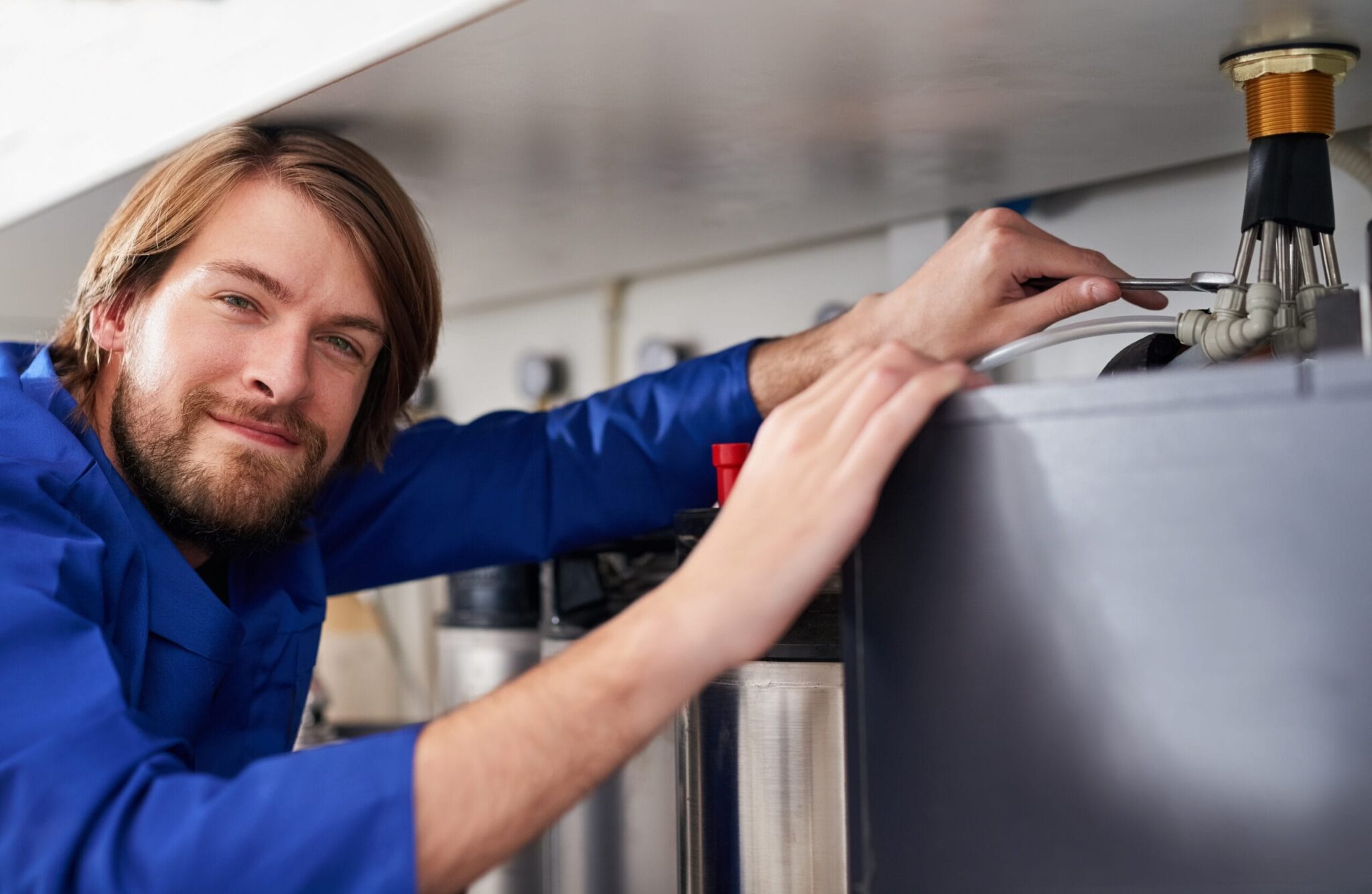 Technician servicing a residential water heater tank in Newnan