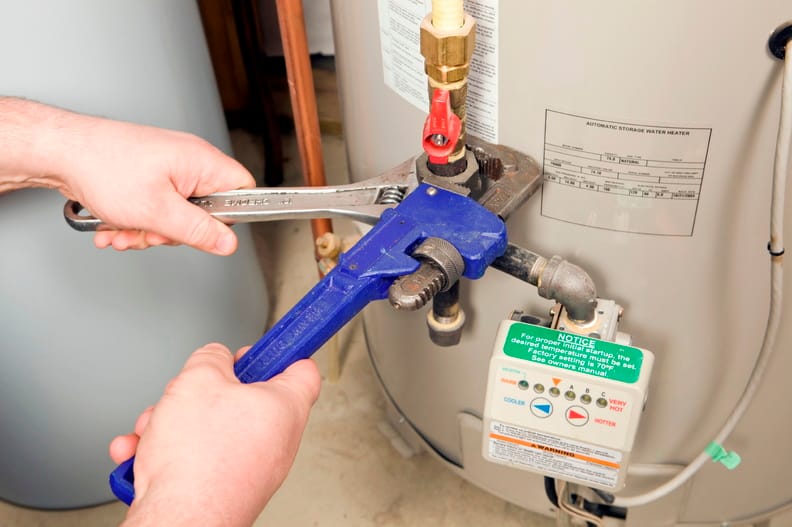Plumber repairing a water heater valve in Newnan